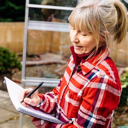 woman with paper/pen planning garden 