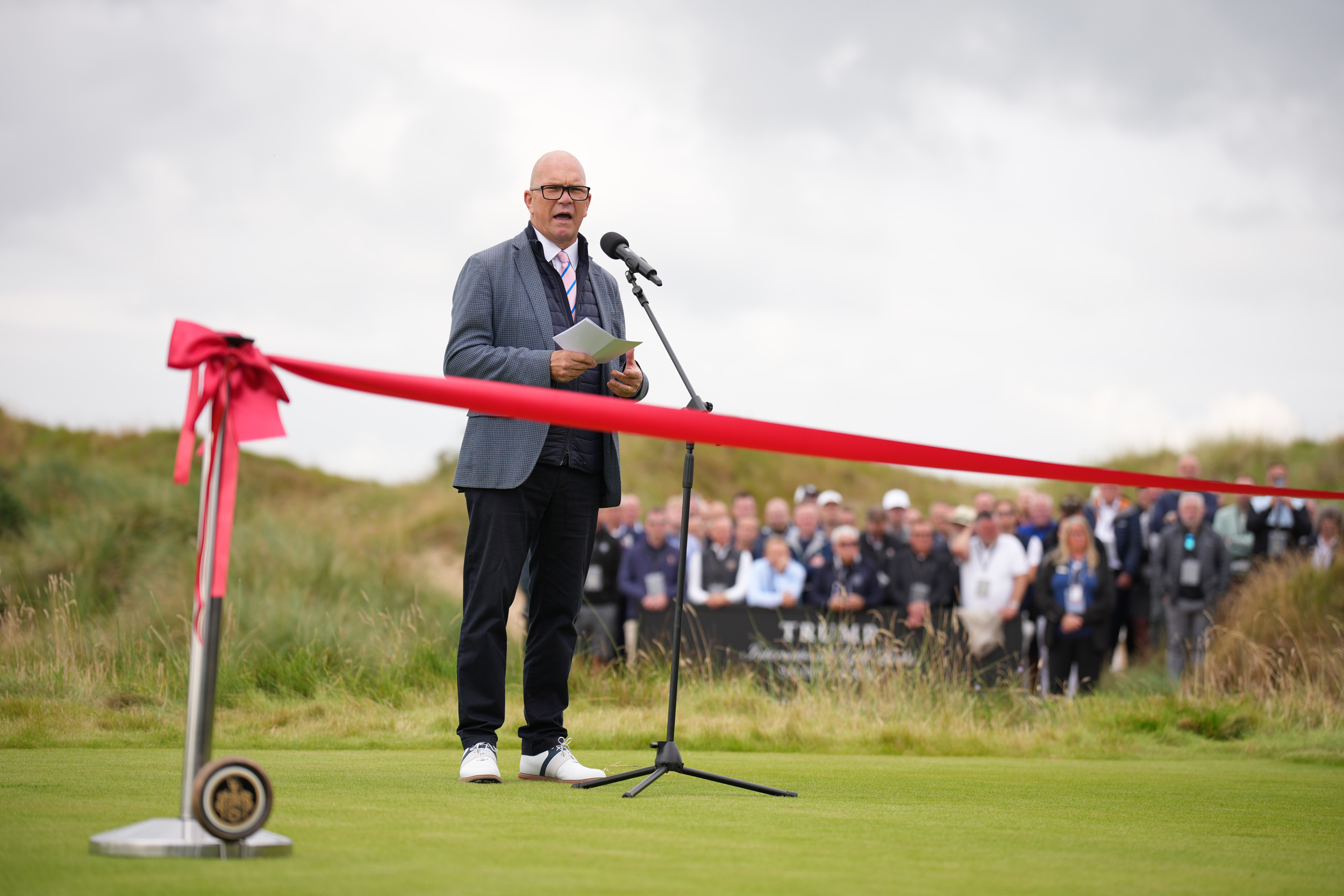 Guy Kinnings speaks at the opening ceremony of Trump International Golf Links in Scotland