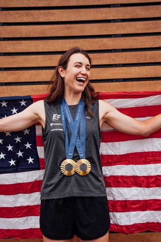 Foto der Radfahrerin Kristen Faulkner mit ihren beiden olympischen Goldmedaillen.