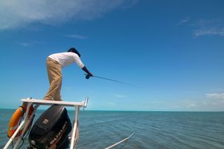 A guide casts his fly at a bonefish swimming on the flats in the Turks & Caicos Islands just off Middle Caicos.