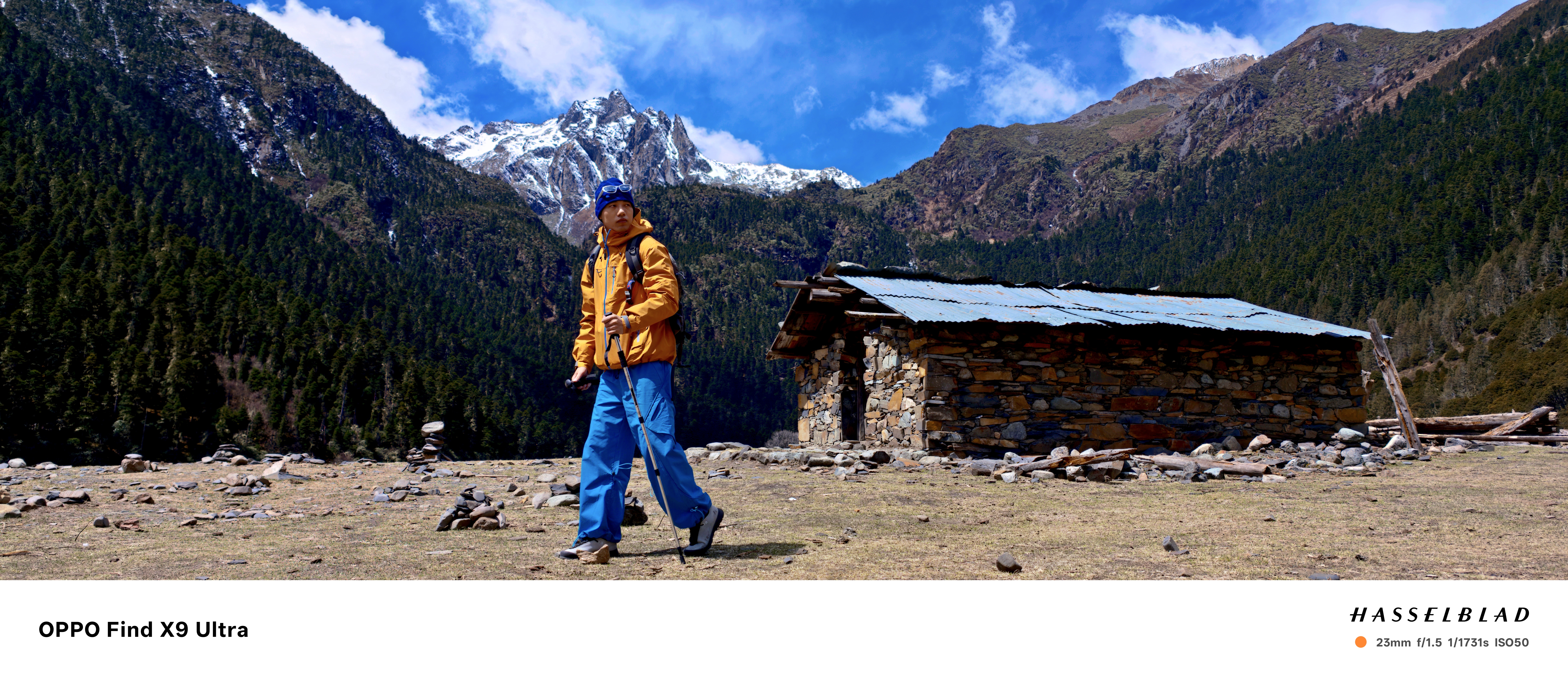 Man in walking gear alongside a bothie and a snowy mountain behind him