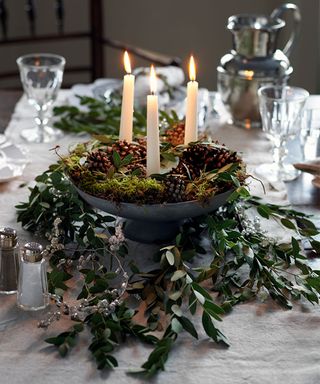 Christmas table centerpiece with greenery and candles