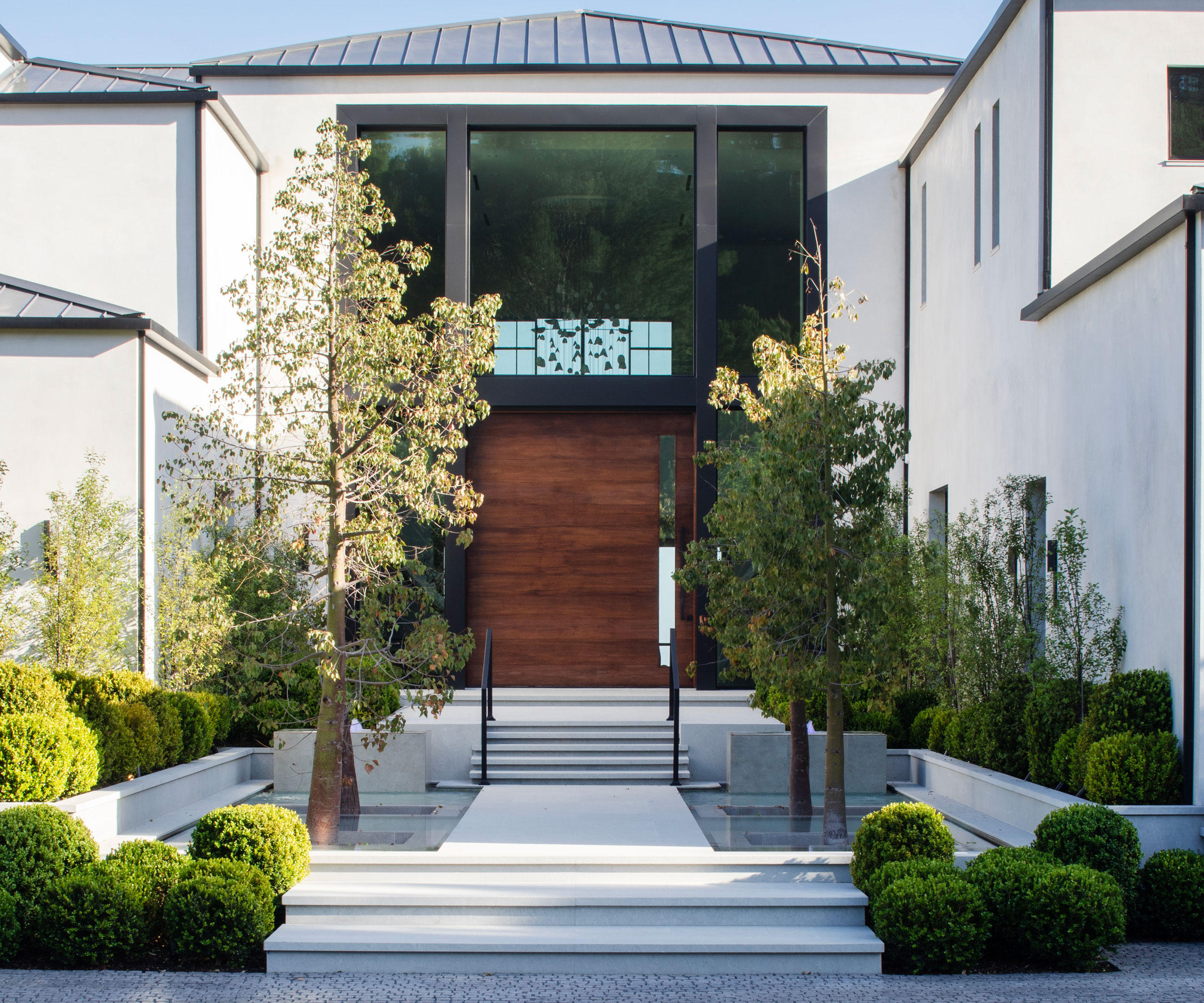 front garden design with path, steps up to front door, raised beds with clipped topiary and small ornamental clipped trees