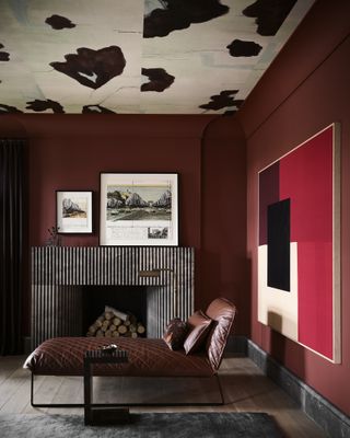 A warm red living room with a brown leather chaise