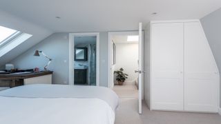 Bedroom with white walls and furniture plus en suite