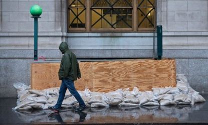 A man walks past a barricaded subway entrance in lower Manhattan as Hurricane Sandy approaches on Oct. 29.