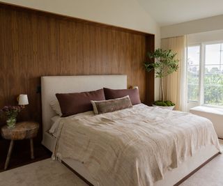 Classic bedroom with neutral colors, with wooden bed frame and green pillows
