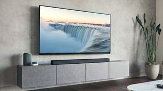 Sony HT-A7000 on bench beneath wall-mounted TV