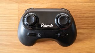 Potensic A20 Mini Drone controller on a wooden table