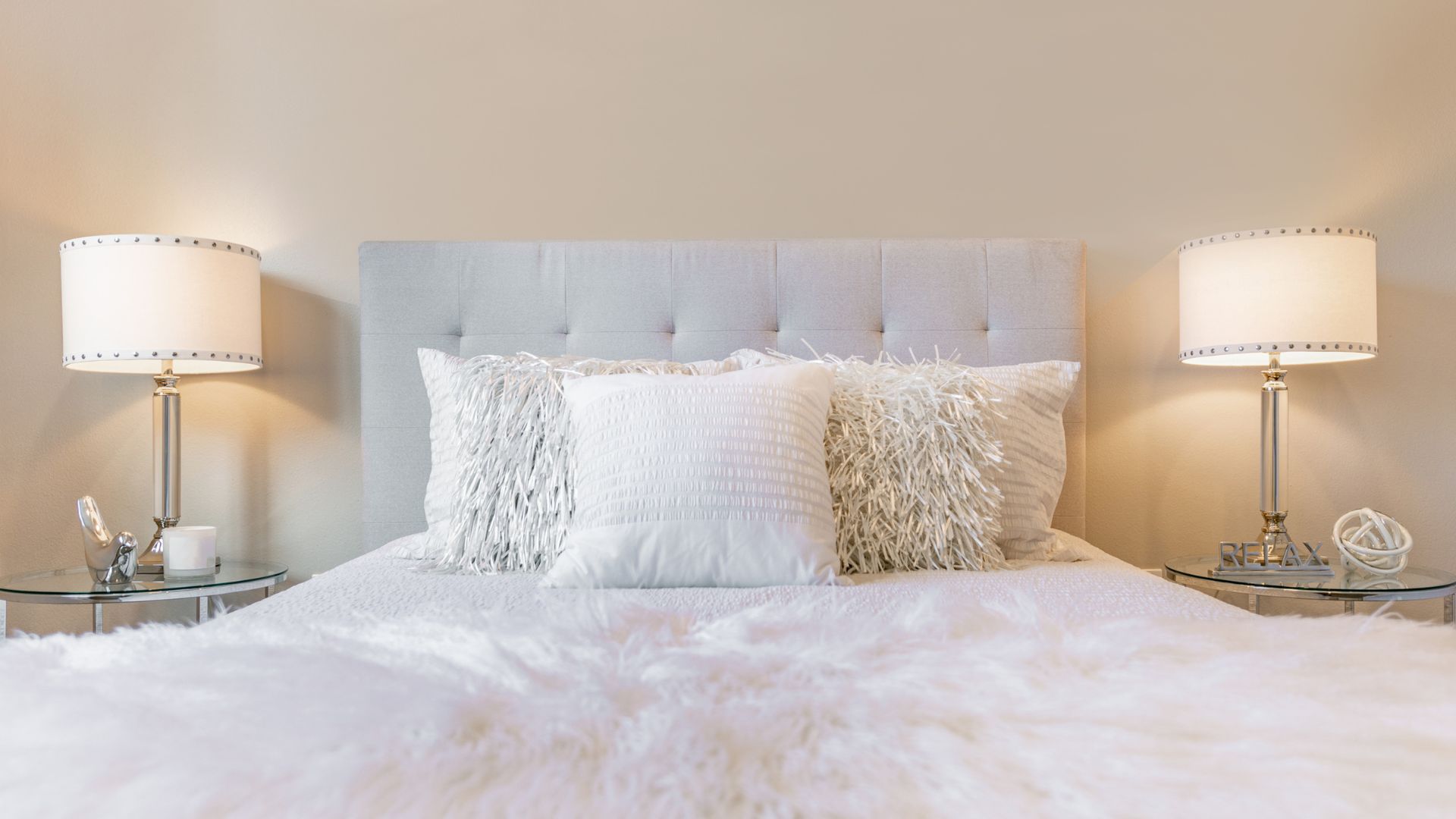 picture of white bedding with dual sided white lamps in neutral room