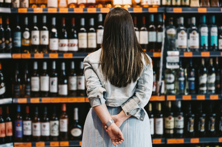 Woman looking at bottles of wine on shelf