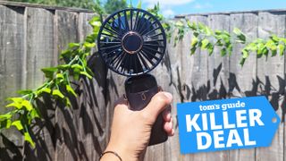 A hand holding a handheld fan