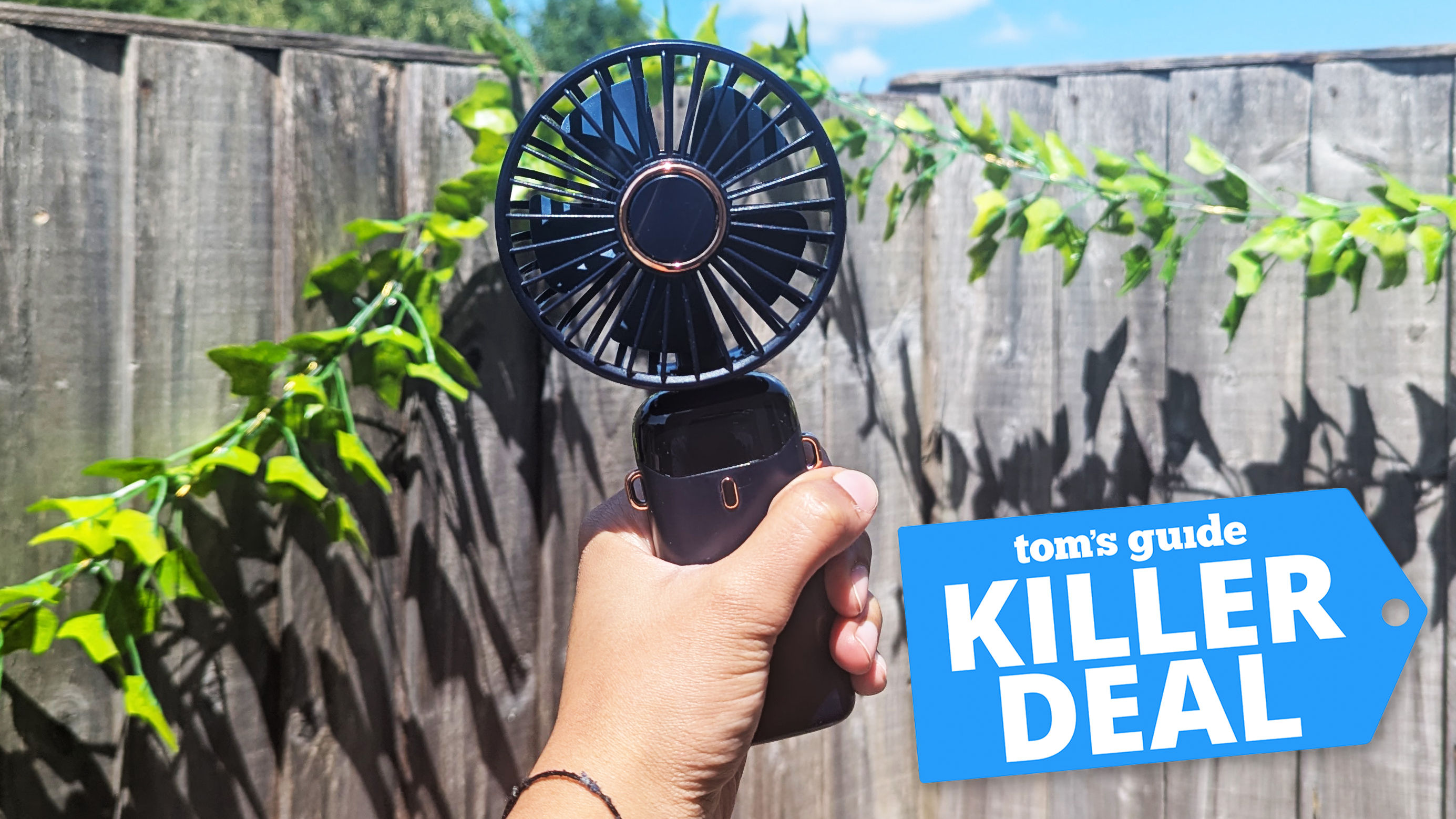 A hand holding a handheld fan 
