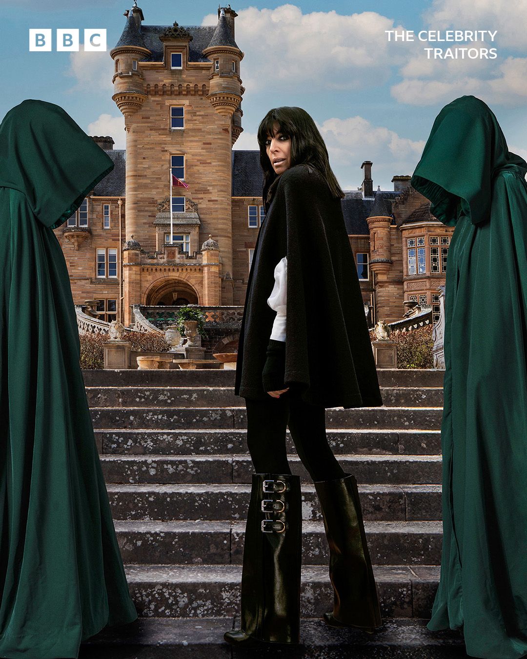 Claudia wearing Givenchy boots, a black cape with a backdrop of a Scottish castle