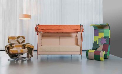 Lounge chair in the beige, brow, and orange geometrical shapes upholstery, a two-seater sofa in pale pink and orange, and a highback chair in purple, yellow, red, and various shades of green upholstery.