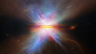 A golden bar of light in the middle of the image is surrounded by rainbow wisps of glowing light in the darkness of space