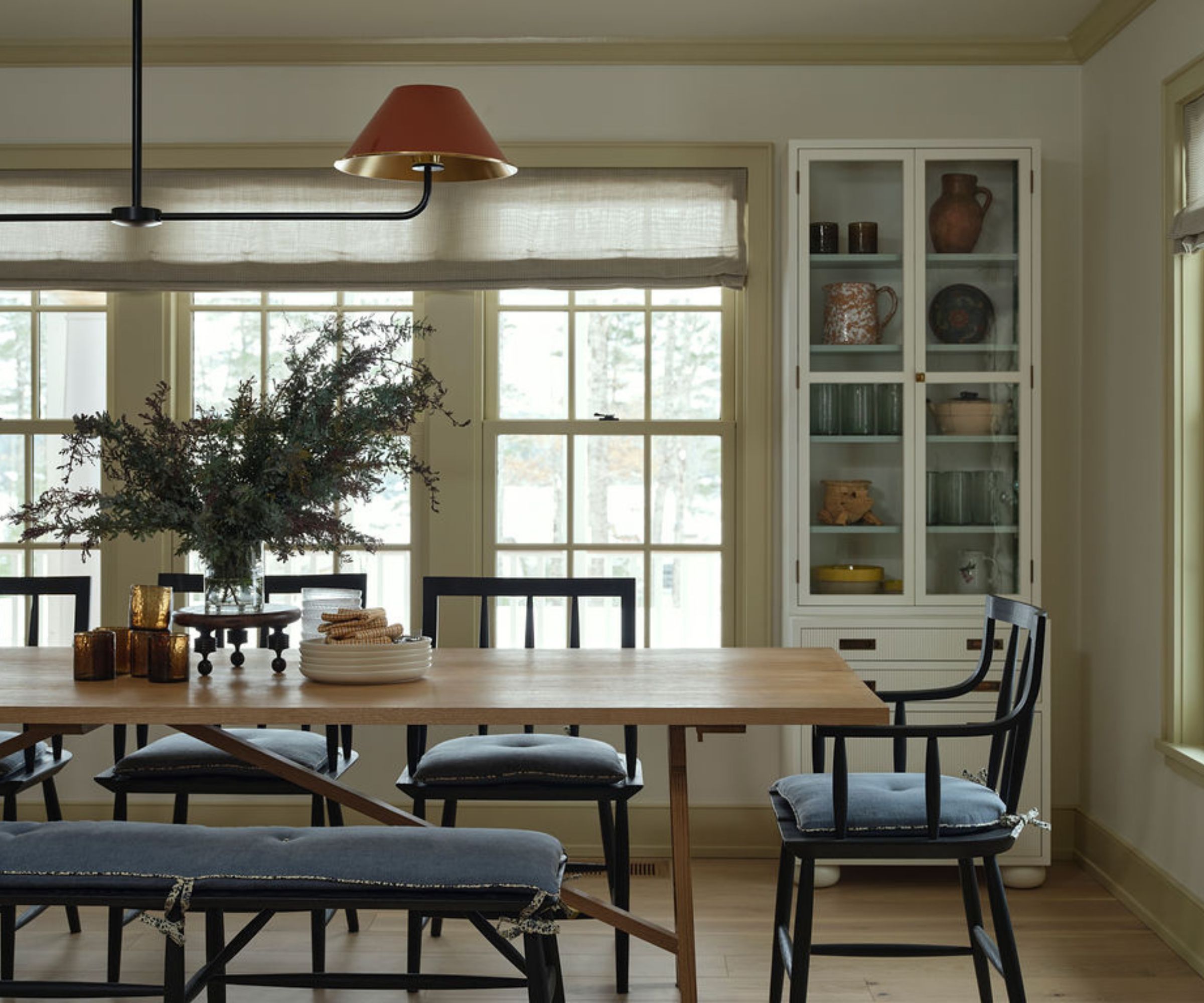 A neutral dining area with a wooden table and dark wood chairs with blue upholstery