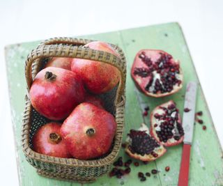 pomegranates in basket and cut pomegranate on chopping board