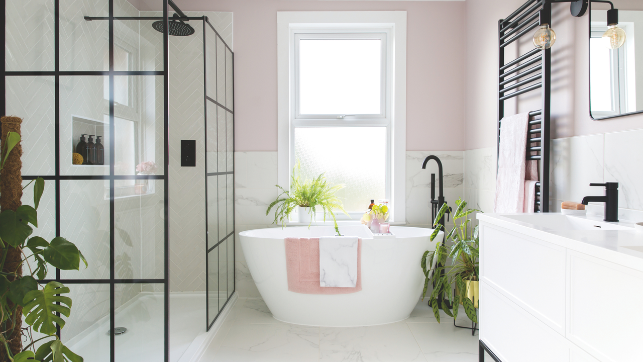 modern bathroom with pale pink painted walls and black hardware.