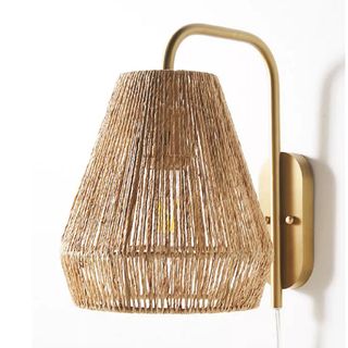A plug in sconce with wicker lampshade