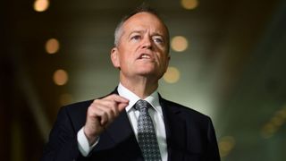 A shot of Australian government services minister Bill Shorten, speaking against a dark background