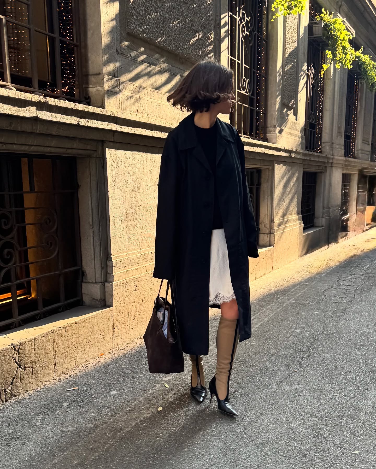 Laura Reilly wearing a lace-trim skirt with a car coat and The Row boots.