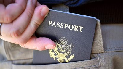 A man places his U.S. passport into his back pocket in Fresno, California.