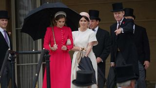 Princess Beatrice and Princess Eugenie exit a garden party in London on a rainy day while wearing nice dresses