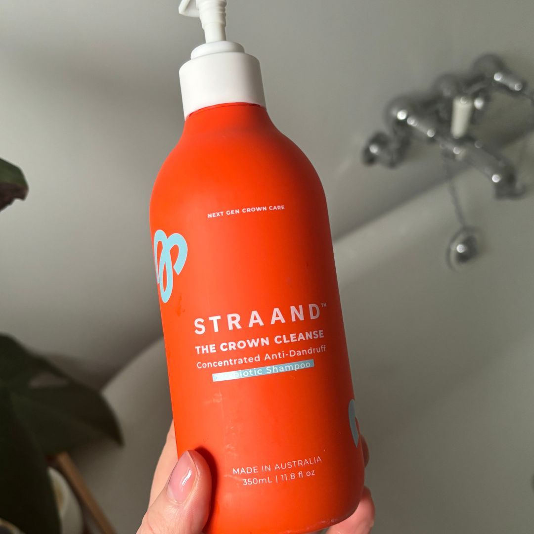 Laura holding STRAAND The Crown Cleanse Concentrated Anti-Dandruff Prebiotic Shampoo