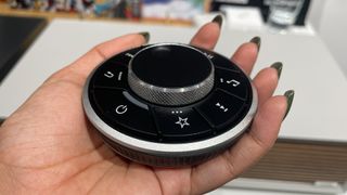 A hand holding the RotoDial controller remote