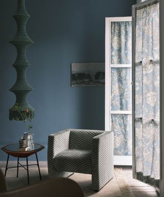 Dark blue painted living room with printed curtains