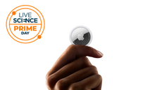 An Apple Airtag held in a hand. 