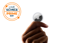 An Apple Airtag held in a hand.