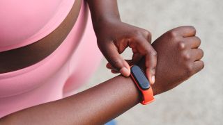 A woman presses a button on her fitness tracker