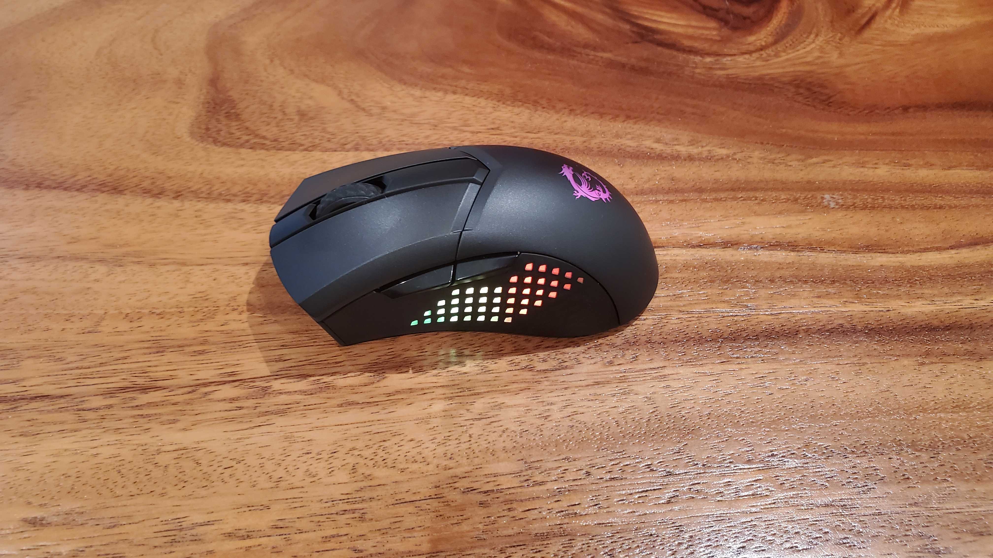 mouse de jogo preto em uma mesa de madeira