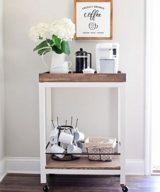 A DIY bar cart coffee cart with coffee equipment and fresh flowers displayed