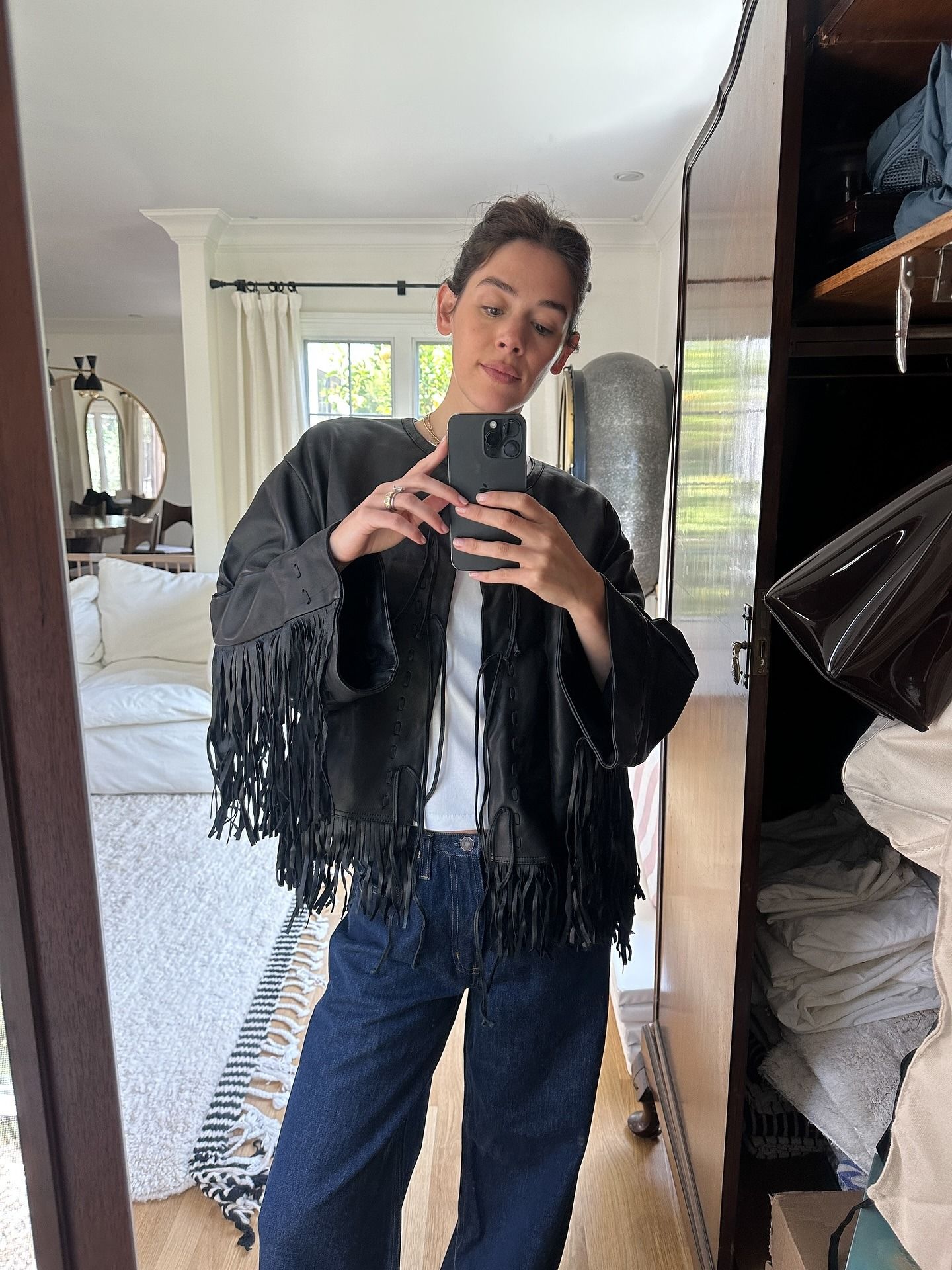 @ilanatorbiner wearing a black fringe jacket and jeans.