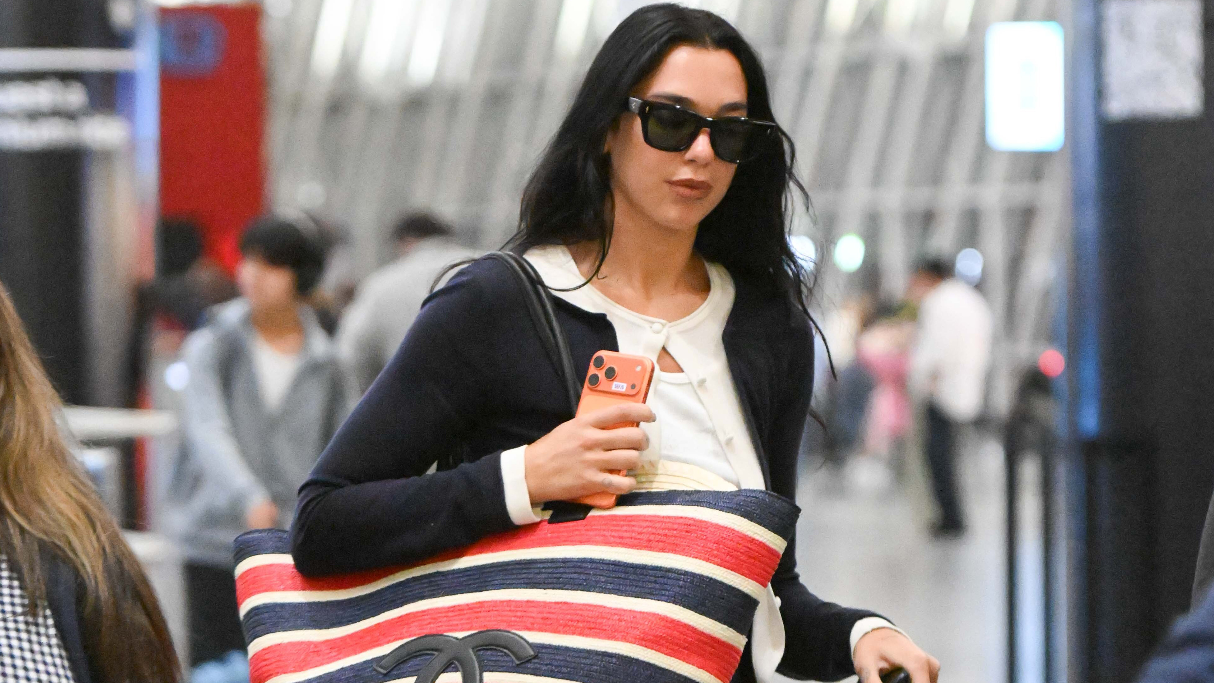 Dua Lipa traveling in a summer airport outfit.