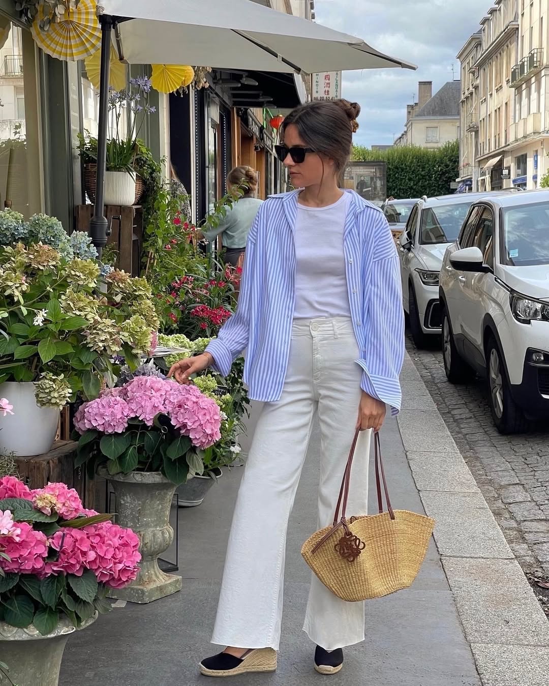 fashion influencer in cream wide-leg jeans and blue shirt
