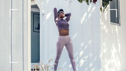Postmenopausal older woman stretching in purple workout clothes against white wooden walls outside