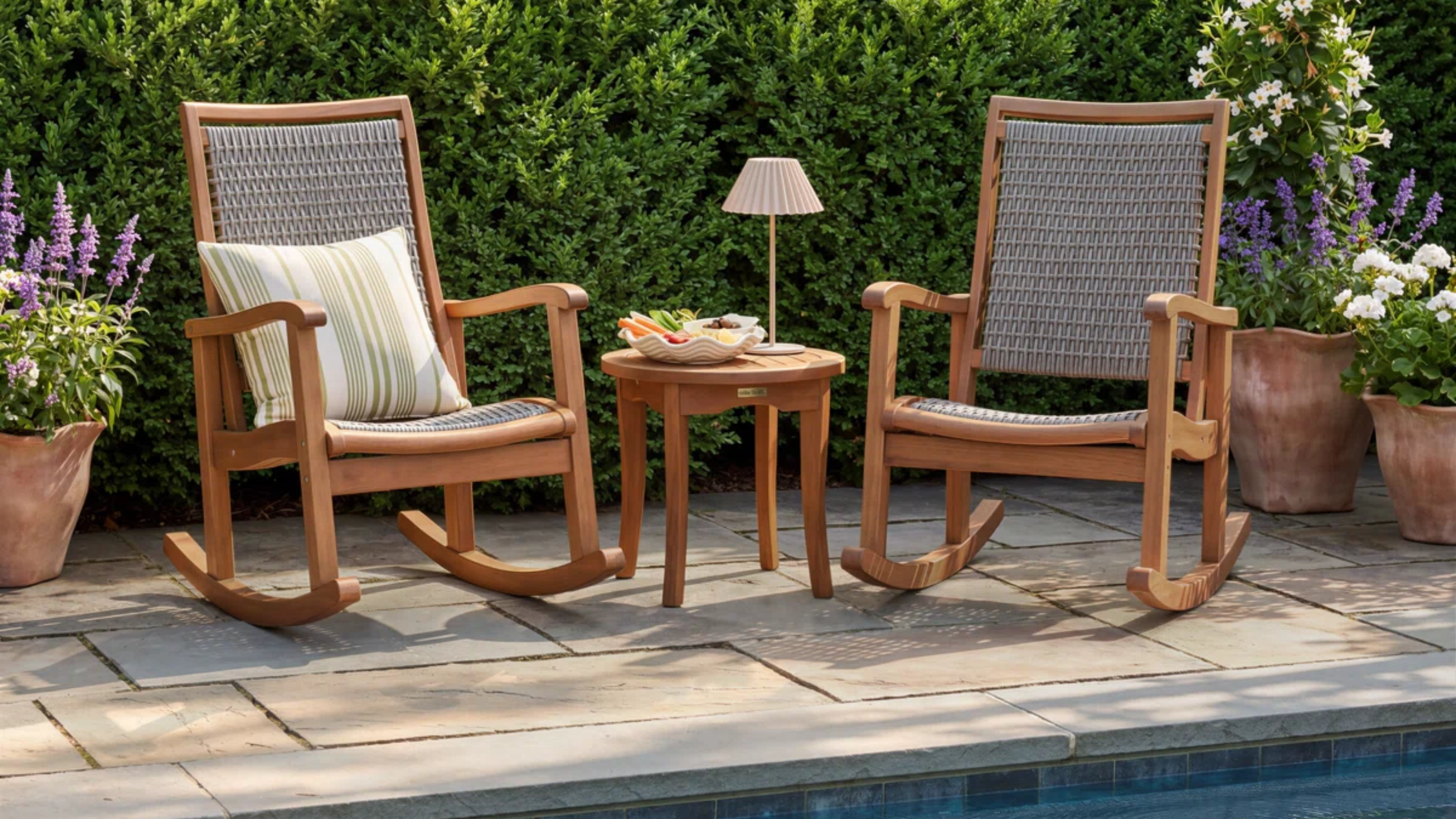 a patio with two rocking chairs and a table 