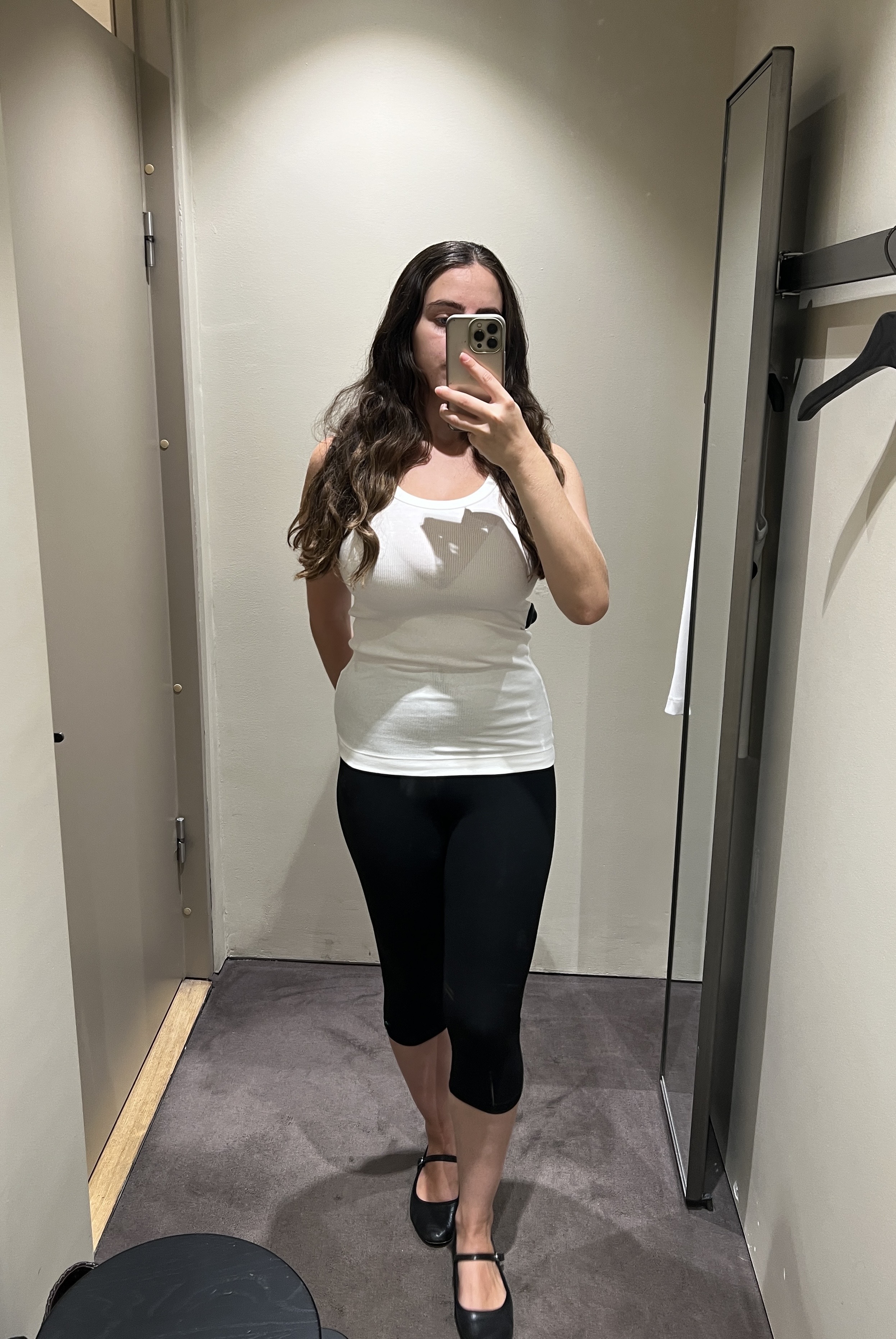 An image ofBest Knockoff Luxury Clothing
's Ava Gilchrist wearing an COS white tank top with capri pants.