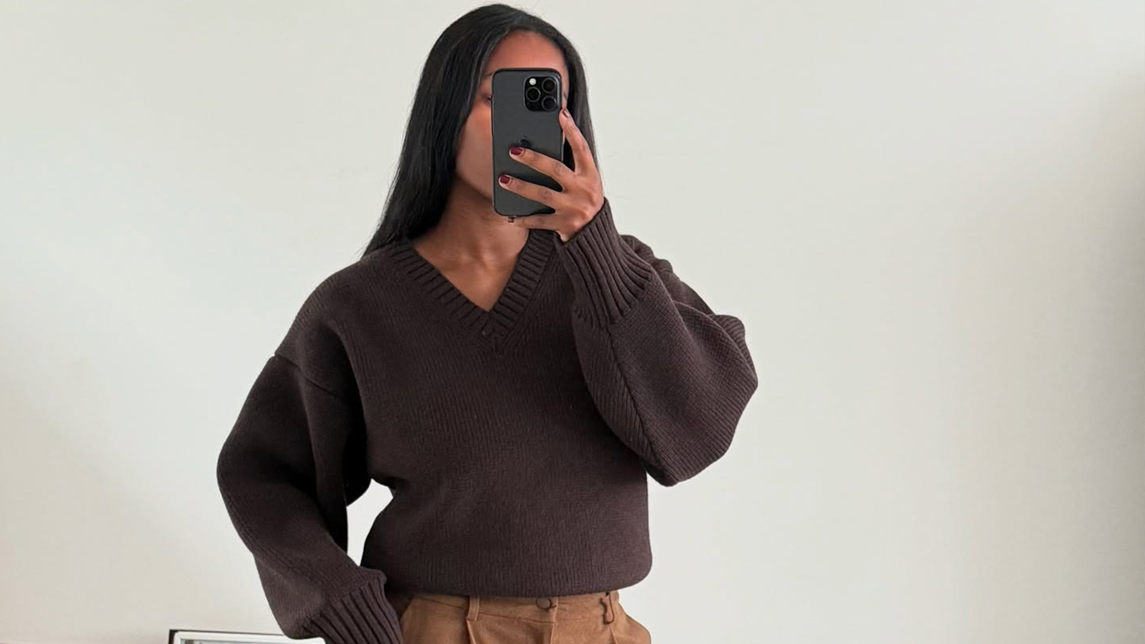 Marilyn wears a brown v-neck sweater.