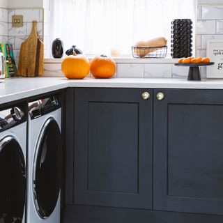 White kitchen with dark grey cabinets and fitted washing machines