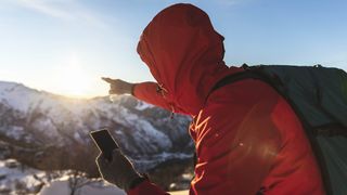 Hiker using phone to navigate in the mountains