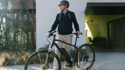 A man walking his electric bike out of his drive