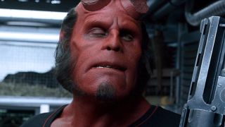 Ron Perlman giving side eye, while holding his gun, in Hellboy.