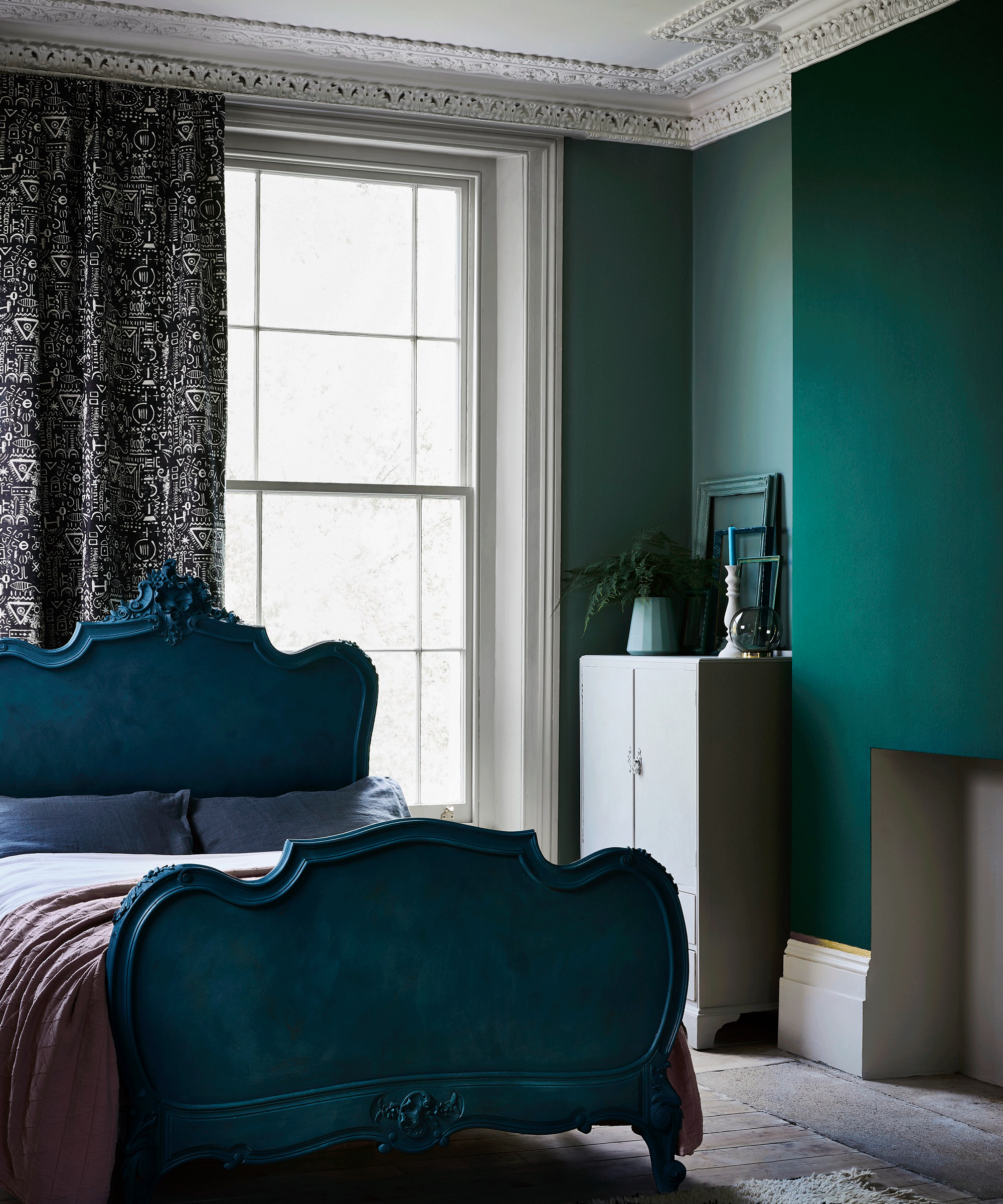Bedroom with blue upholstered headboard and green walls