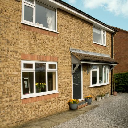 house with brick wall and potted plants