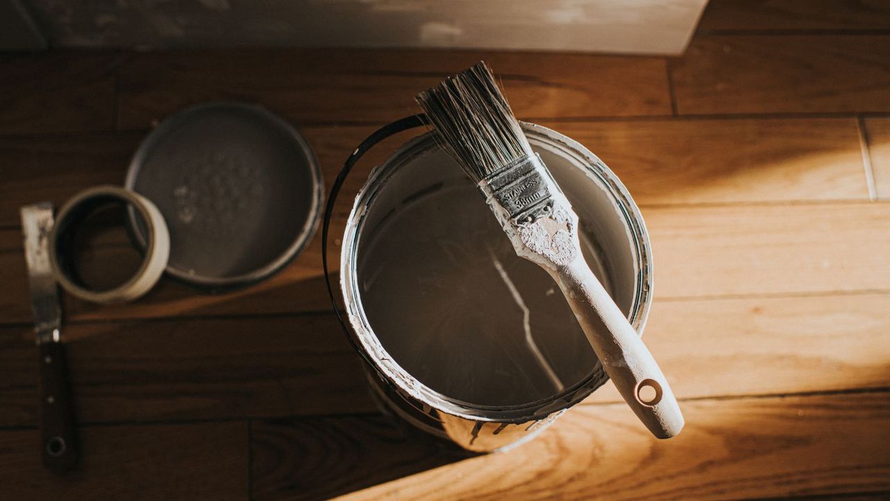 A paint tin with a paint brush resting on top